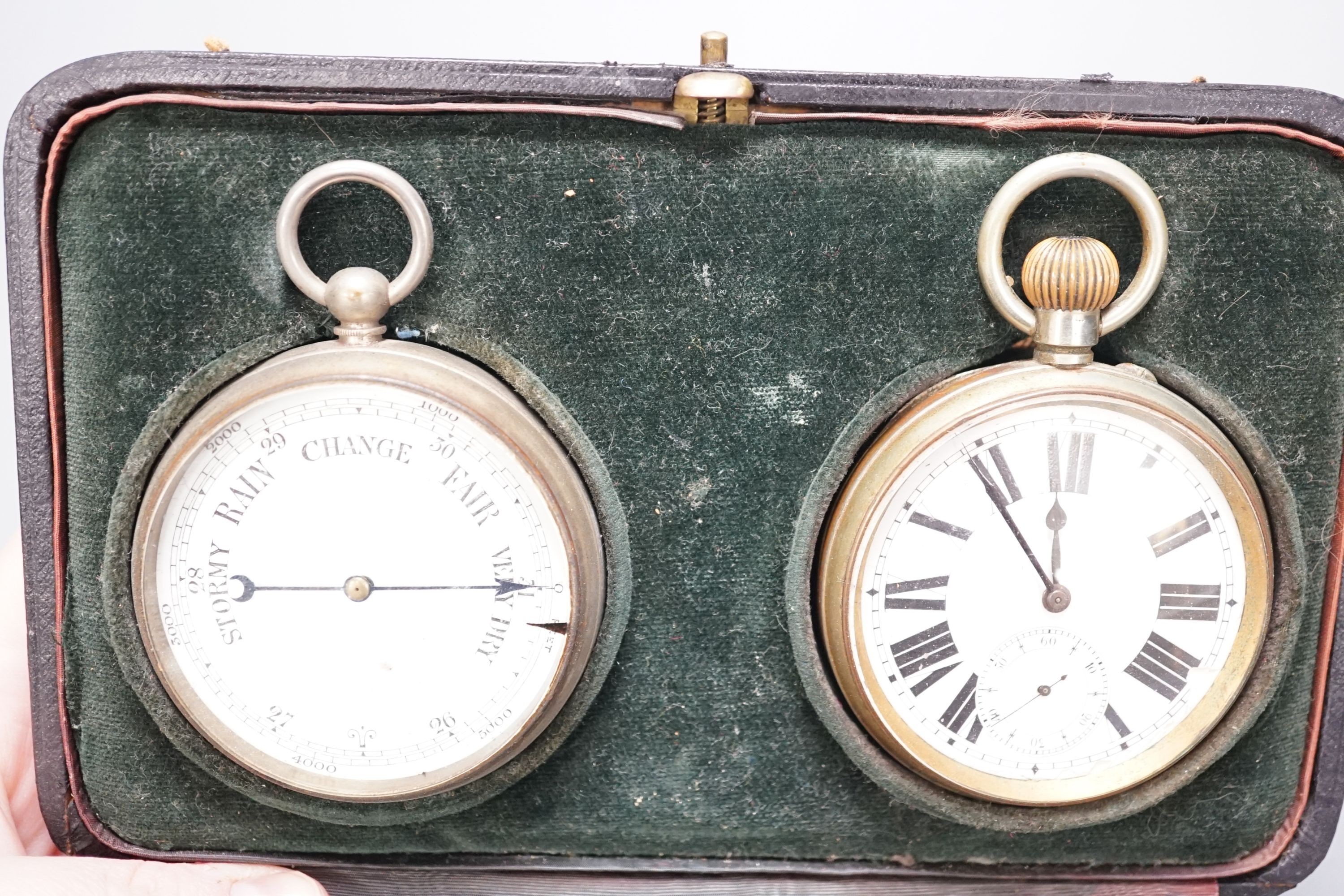 A leather cased pocket watch and barometer with central thermometer, 19.5 cm wide x 13 cms high.